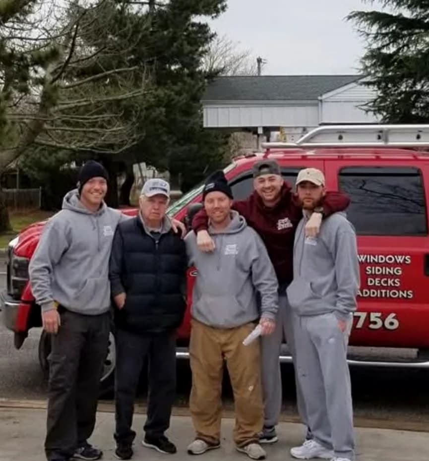 Tomes Roofing and Contracting crew standing together beside a company truck